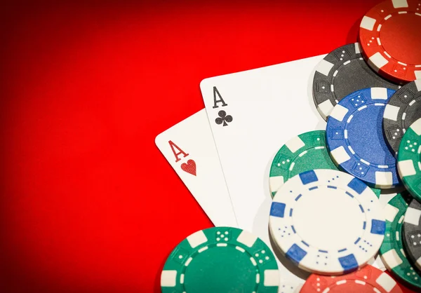 Pair of aces and chips on a red table