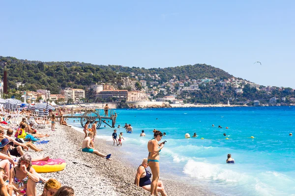 Ourists enjoy the good weather at the beach in Nice, France