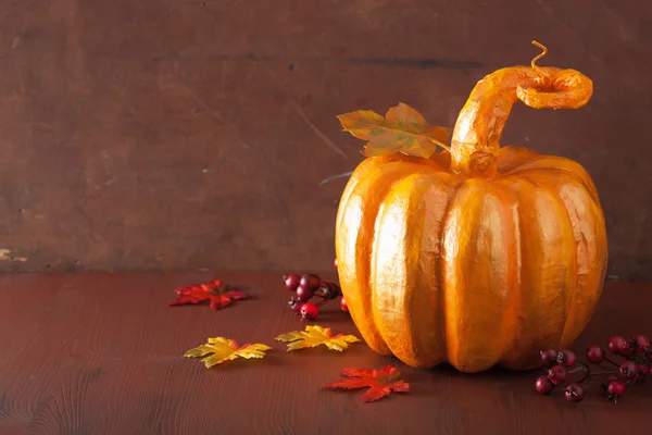 Decorative golden papier-mache pumpkin and autumn leaves for hal