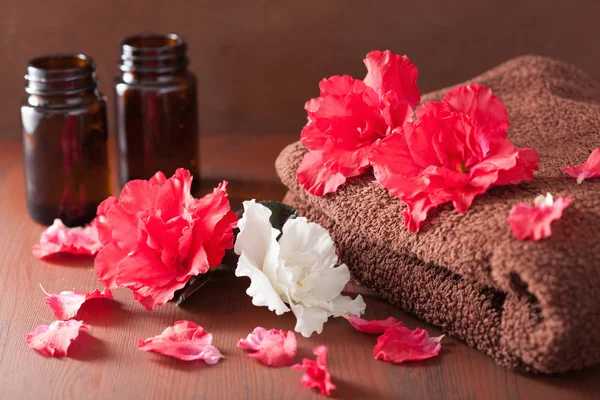 Spa bathroom with azalea flowers essential oil on dark rustic ba