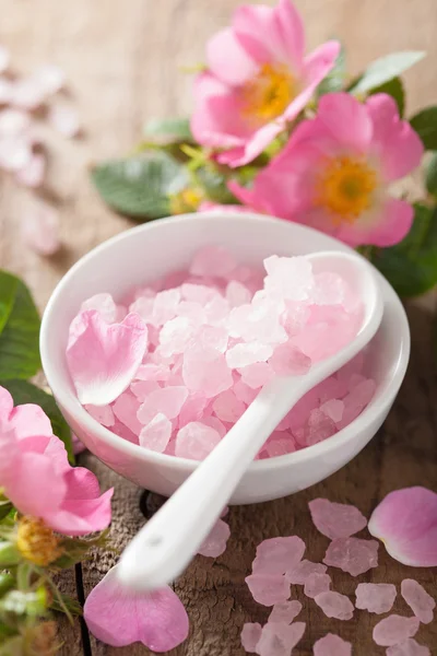 Spa with pink herbal salt and wild rose flowers