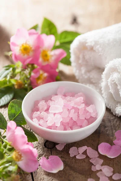 Spa with pink herbal salt and wild rose flowers