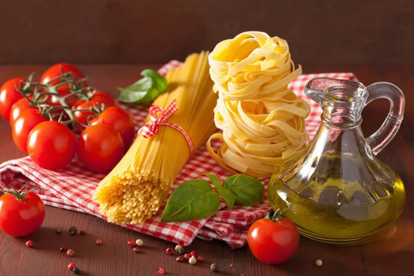 Raw pasta olive oil tomatoes. italian cuisine in rustic kitchen