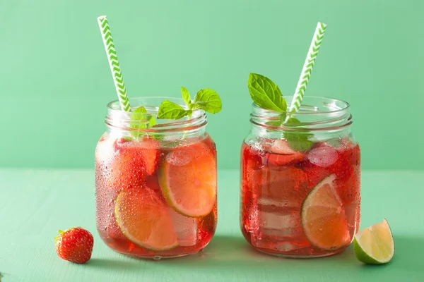 Summer strawberry drink with lime and mint in jars