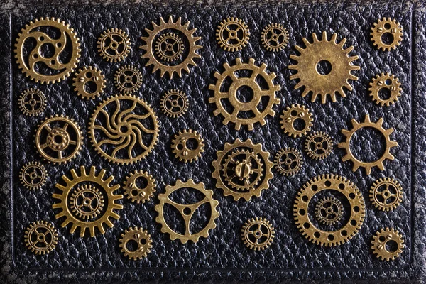 Steampunk mechanical cogs gears wheels on leathern background