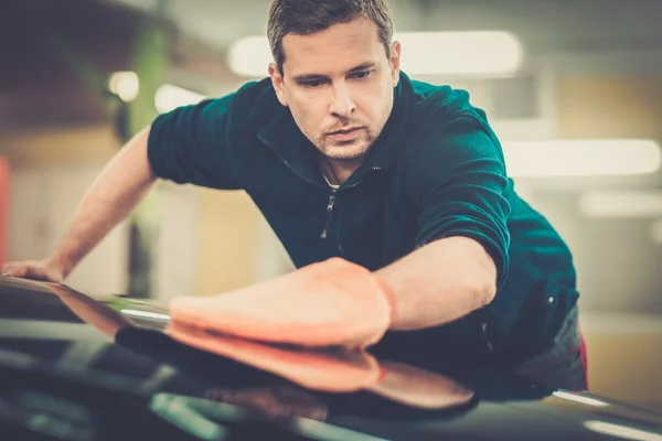 Man worker polishing car on a car wash