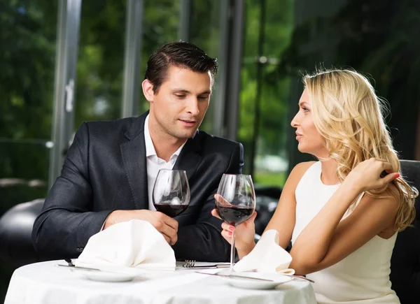 Cheerful couple in a restaurant with glasses of red wine