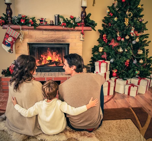 Family near fireplace in Christmas decorated house interior