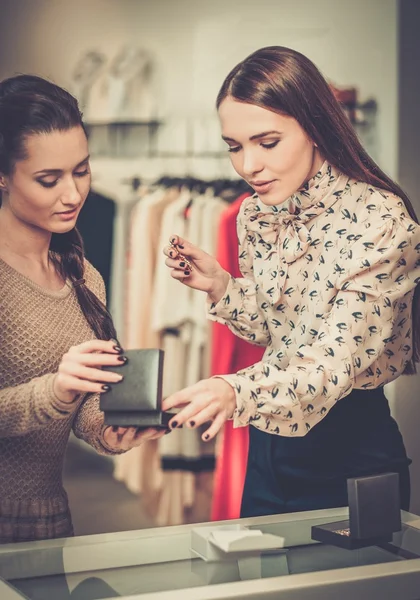 Woman choosing jewellery with shop assistant help