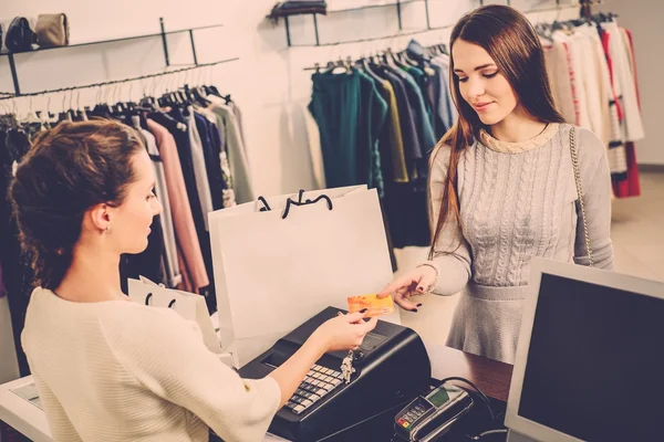 Woman paying with credit card in fashion showroom
