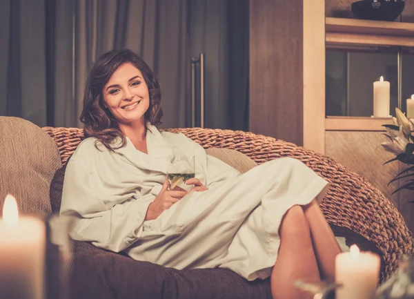 Beautiful woman relaxing in a bathrobe in spa salon