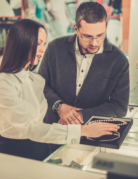 Man with assistant help choosing jewellery