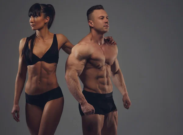Fitness couple isolated on grey background
