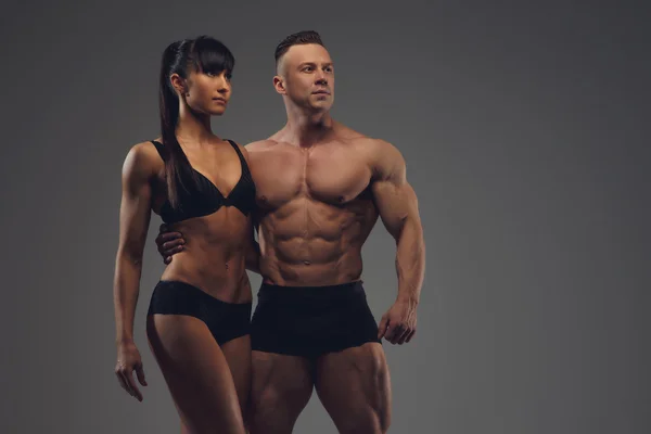 Fitness couple isolated on grey background