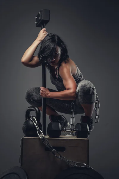 Woman with cross fit hummer and chain