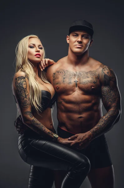 Modern tattooed couple posing in a studio