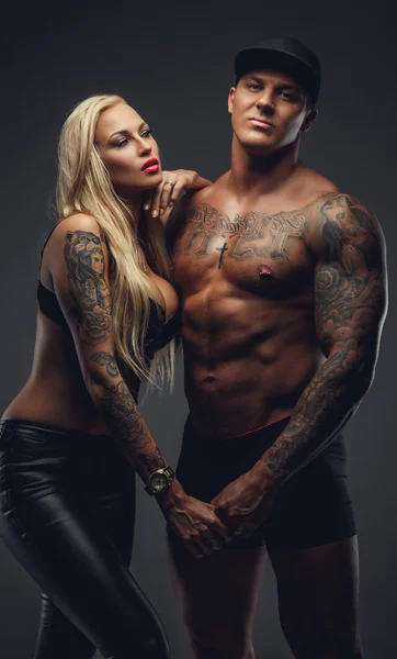 Modern tattooed couple posing in a studio