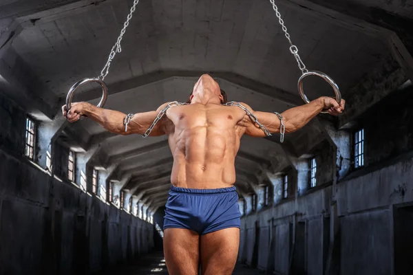 Man workouts with gymnastic rings