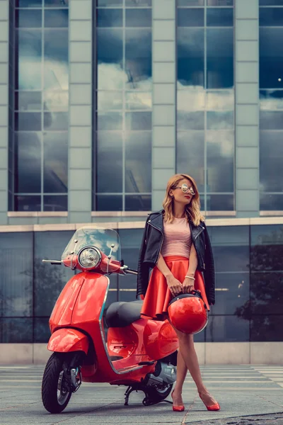 Female posing near motor scooter