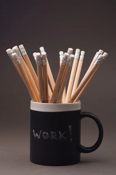 Graphite pencils in a black cup.