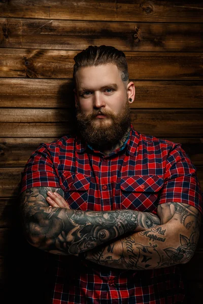 Tattooed bearded male in a red shirt.