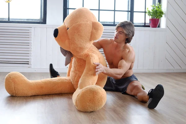 Male posing with big teddy bear