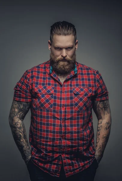 Tattooed male in a red shirt.