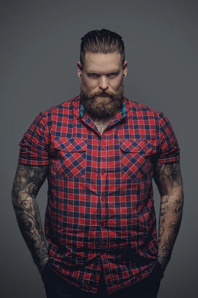 Tattooed male in a red shirt.