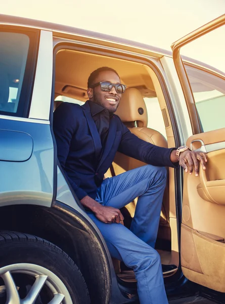 African male posing in a car
