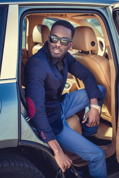 African male posing in a car