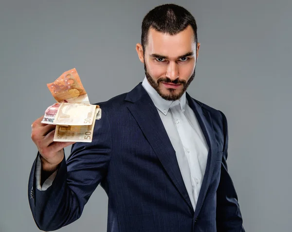 Bearded male in a suit holding cash