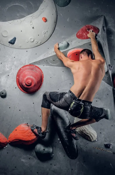 Male climbing on an indoor climbing wall