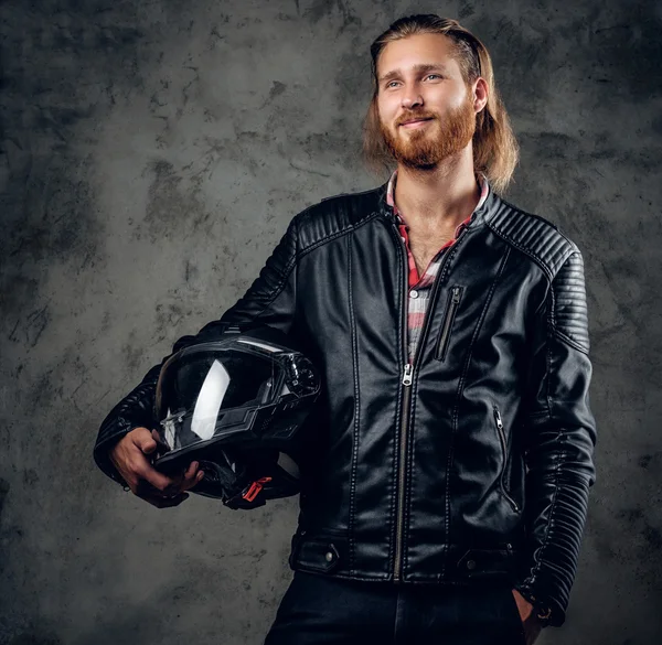 Redhead male holds motorcycle helmet