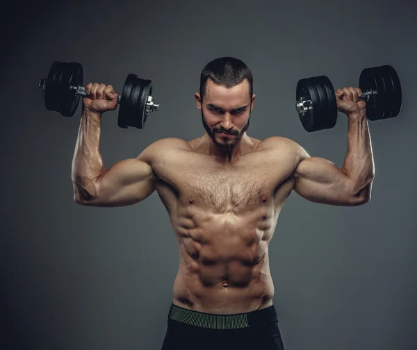 Man holds dumbbells with arms up