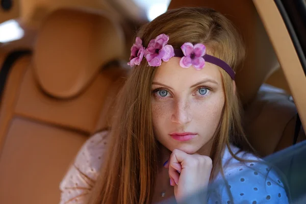 Freckled girl in a car on back seat