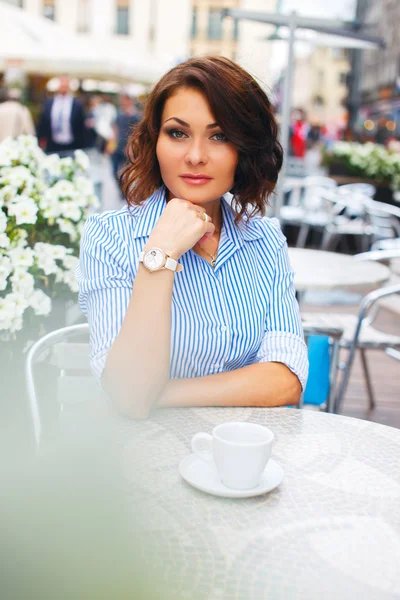 Woman in blue blouse at a cafe.