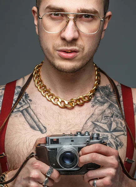 Tattooed man holding photo camera