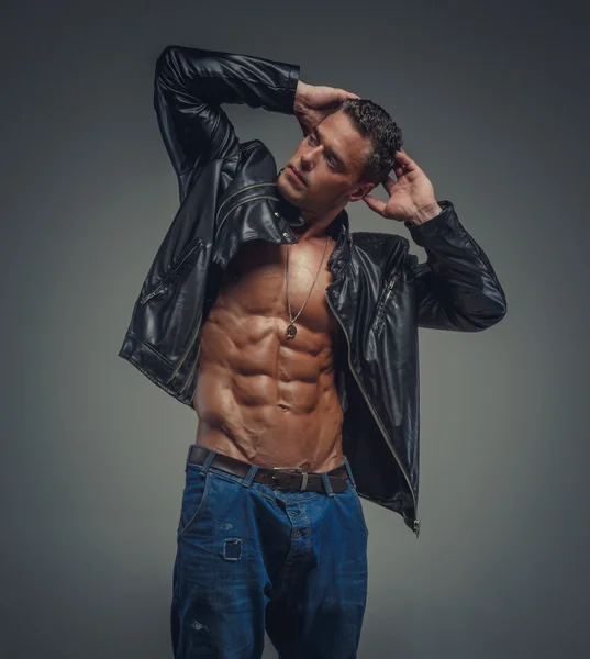 Muscular guy in jeans and black jacket
