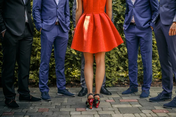 Five mans in suits and one female in orange dress.