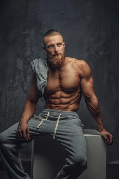 Portrait of muscular shirtless man with beard.
