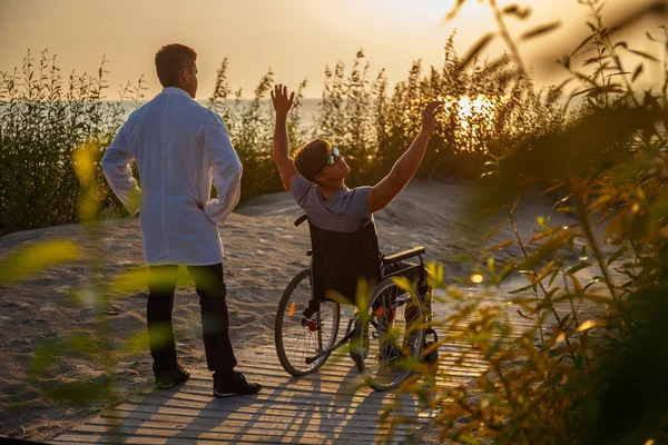 Young man in wheelchair and his doctor.