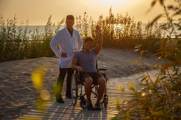 Young man in wheelchair and his doctor.