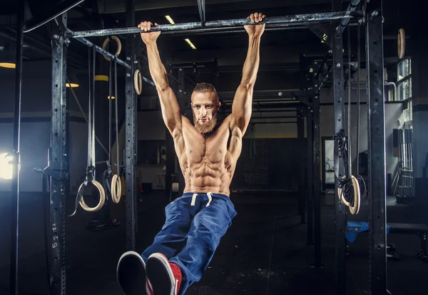 Bodybuilder with beard doing pull ups.