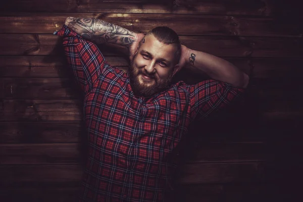 Smiling man with tattooes and beard.