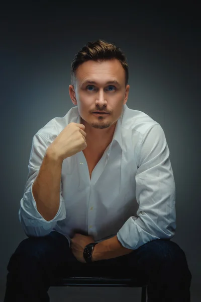 Elegant man in white shirt possing in studio.