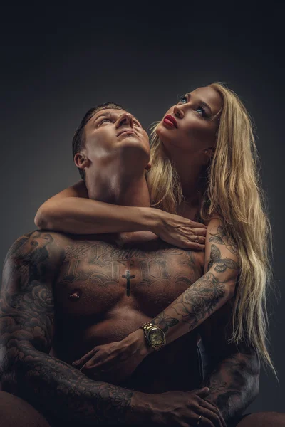 Tattooed man and blond woman.