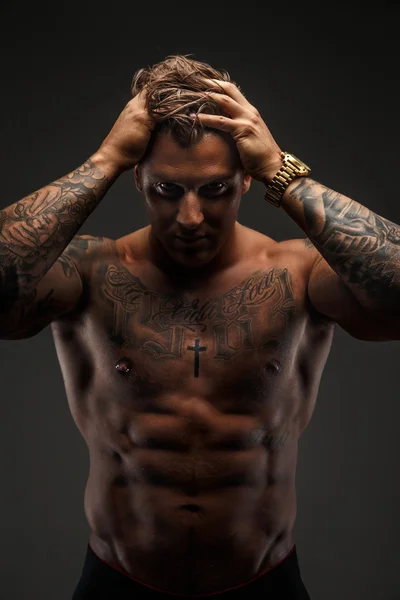 Shirtless muscular tattooed man.