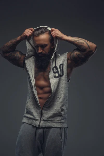 Muscular tattooed man with beard.
