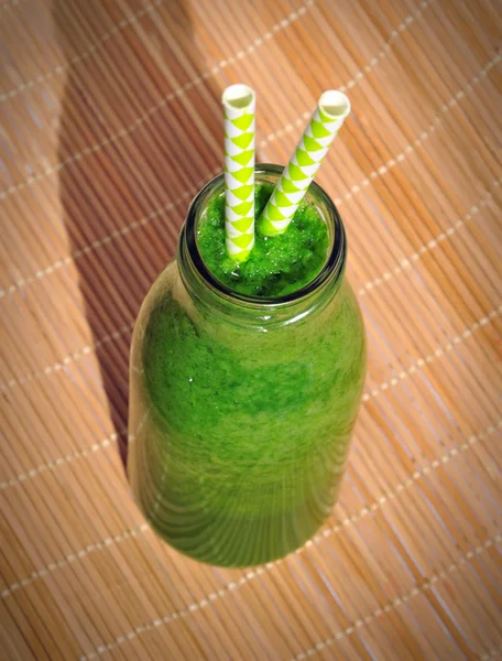 Green spinach smoothie in jar with straws. Healthy breakfast concept