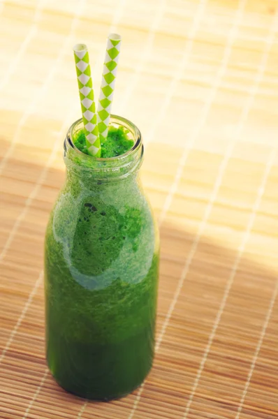 Green spinach smoothie in jar with straws. Healthy breakfast concept